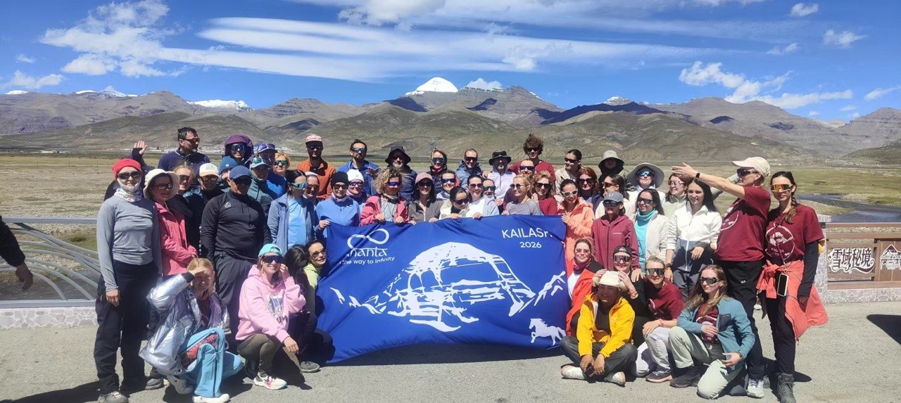 Large tour group with banner in front of mountains