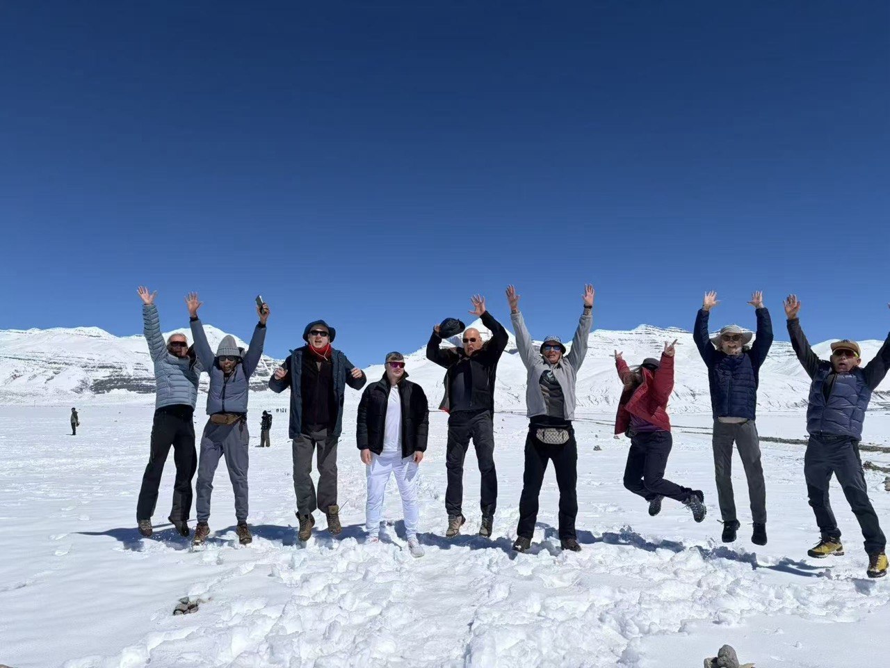 Group jumping for joy in snowy mountain landscape